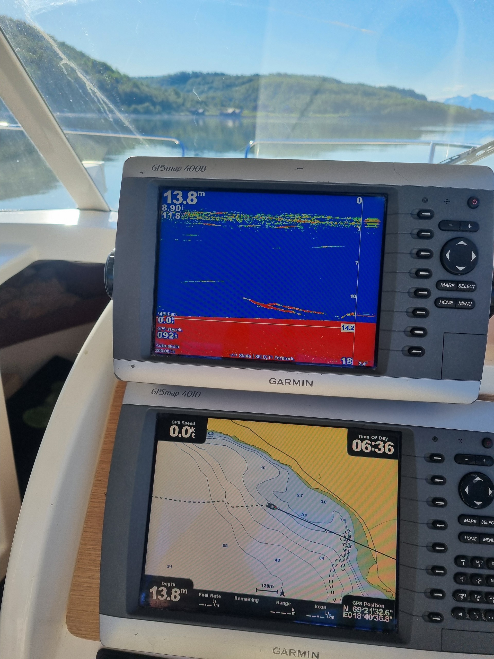 Boat navigation system displaying maps and sonar readings on two screens.