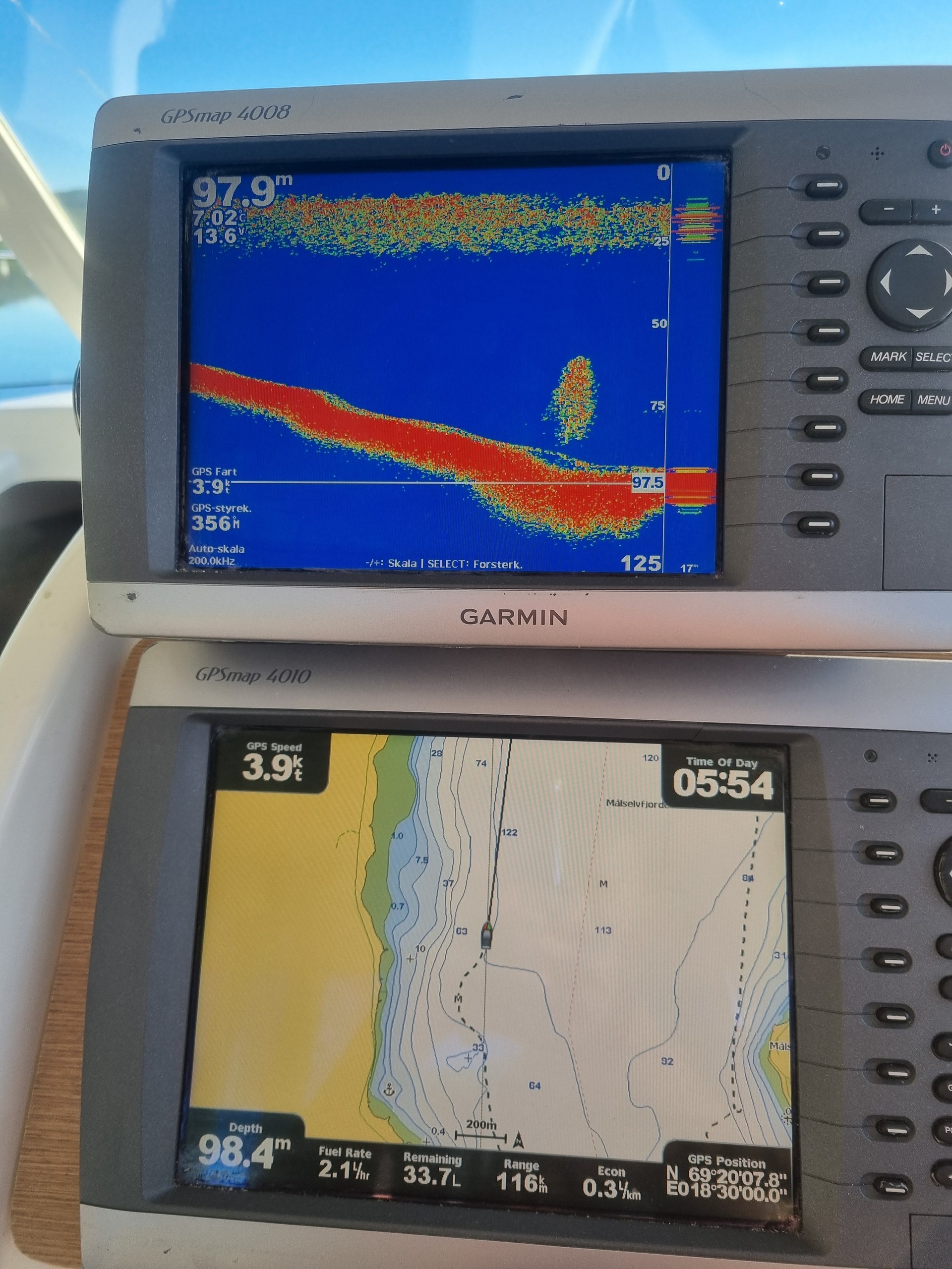 Boat navigation system with two Garmin screens displaying sonar and a map.